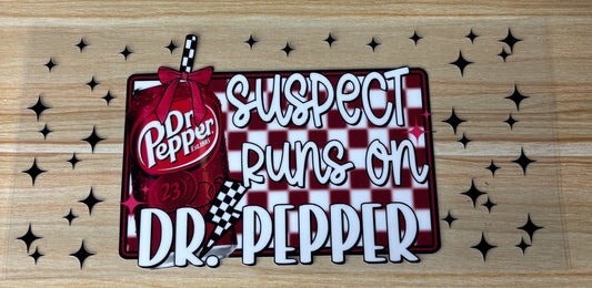 a red and white checkered sign with the text "Suspect Dr. Pepper runs on Dr. Pepper" and a picture of a red and white striped bottle of Dr Pepper.