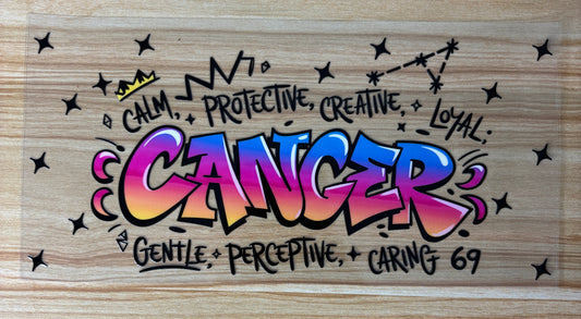 a colorful graffiti-style artwork with the word "Cancer" prominently displayed. The artwork includes various words and phrases such as "Calm", "Protective", "Creative", "Loyal", and "Gentle", which are written in a stylized and artistic manner. The overall design and color scheme of the artwork create a visually striking and expressive piece.