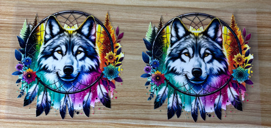 two colorful and vibrant dreamcatchers with the head of a wolf or wolf-like creature. The dreamcatchers are adorned with feathers, flowers, and other natural elements, creating a visually striking and artistic composition.
