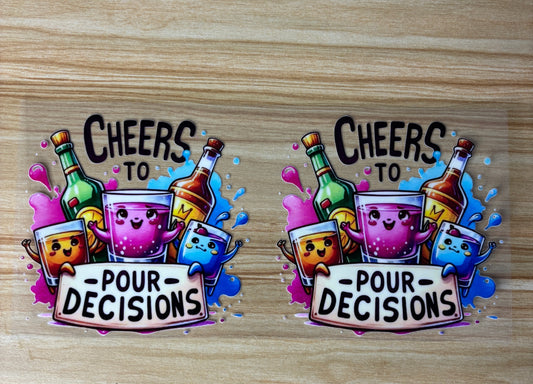 two stickers with a cheerful and colorful design, featuring cartoon-style characters and text. The stickers are placed on a wooden surface.