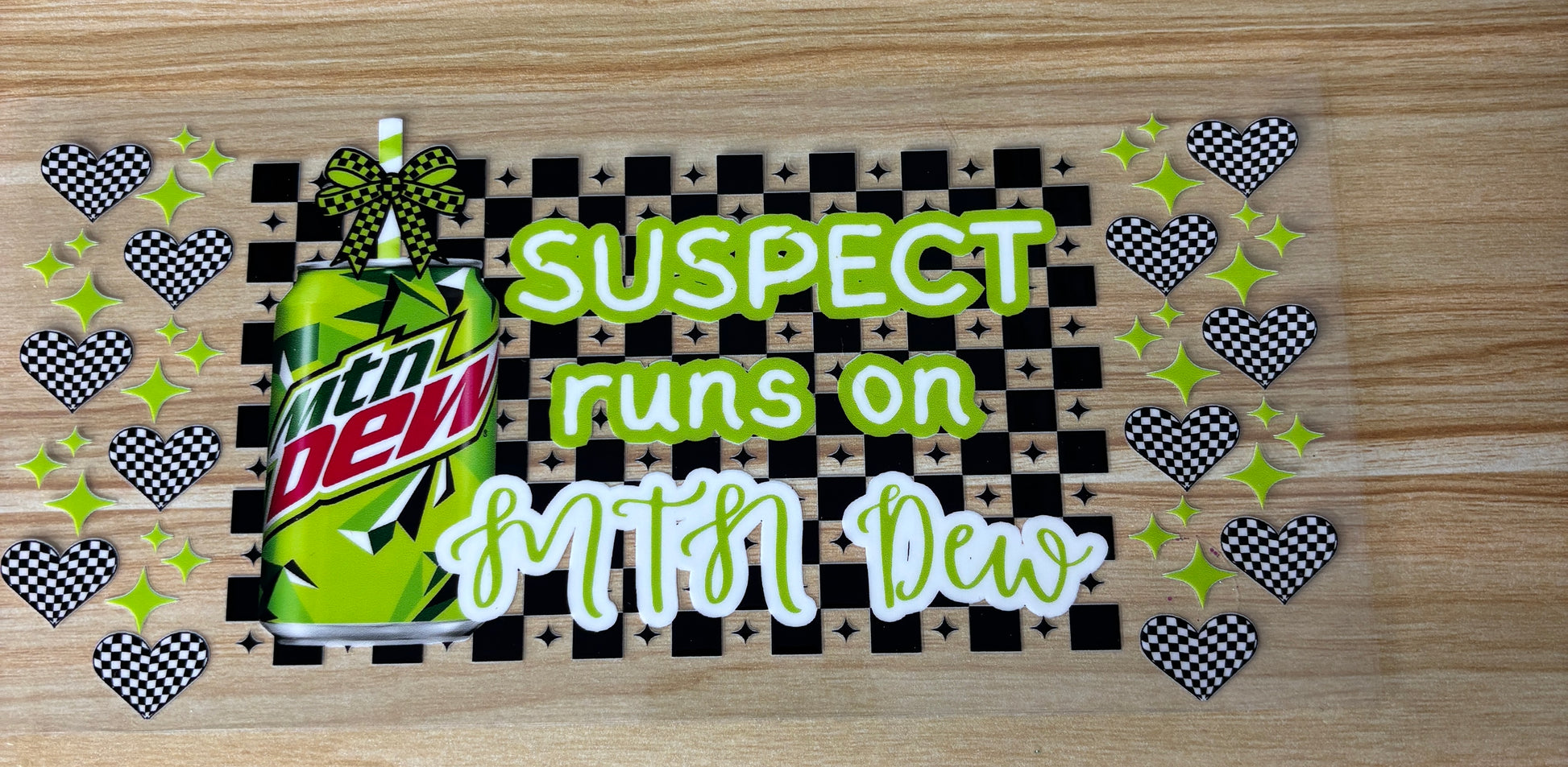a can of Mountain Dew with a checkered pattern and a text overlay that reads "SUSPECT runs on Mtn Dew".